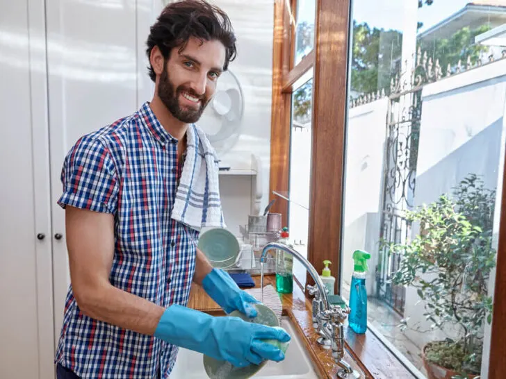 man washing dishes with eco-friendly sponge
